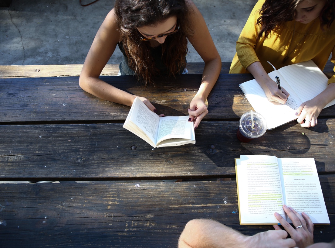 image of students writing at a table